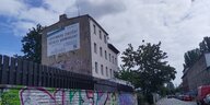 "Lichtenberg zerstört soziales Wohnprojekt" steht auf einem Protestbanner, das an einer Wand hängt - eben den von Schließung bedrohten Heim für suchtkranke Obdachlose