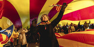Eine Frau unter einer katalonischen Fahne