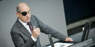 Bundeskanzler Olaf Scholz (SPD), spricht bei der Generaldebatte des Bundestags mit einer Augenklappe