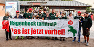 Mitarbeiter des Tierparks Hagenbeck halten vor dem Eingang ein Banner mit der Aufschrift "Hagenbeck tariffrei? Das ist jetzt vorbei!" in den Händen.