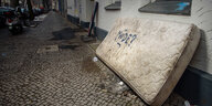 Eine alte Matratze mit der Grafitti-Aufschrift «Müde?» lehnt an einer Hauswand in Berlin-Neukölln