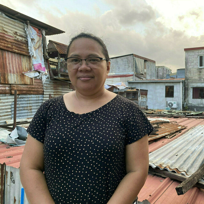 Portraitfoto von Veronica Cabe, die auf dem Dach ihres Elternhauses steht