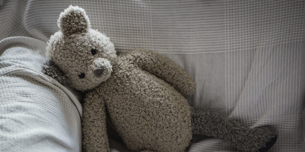 Ein Teddybär liegt auf einem sofa