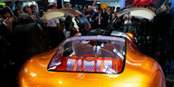 oranger Wagen mit Flügeltüren, von Zuschauern bewundert