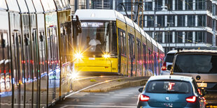 Tram fährt an Autos vorbei