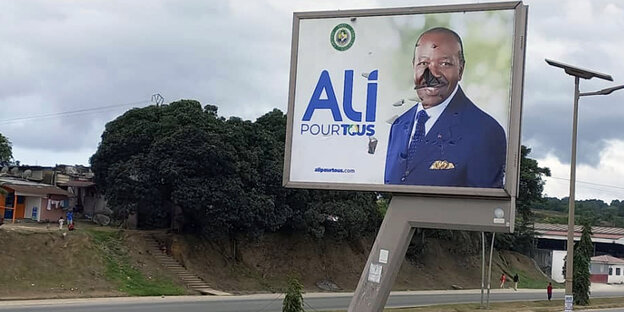 Plakat des gabunischen Präsidenten Ondimba an einer leeren Straße in Libreville