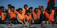 Migranten aus Eritrea, Libyen und dem Sudan drängen sich mit Rettungswesten bekleidet auf dem Deck eines Holzbootes