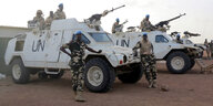 Uno Soldaten mit stehen bewaffnet neben gepanzerten Fahrzeugen