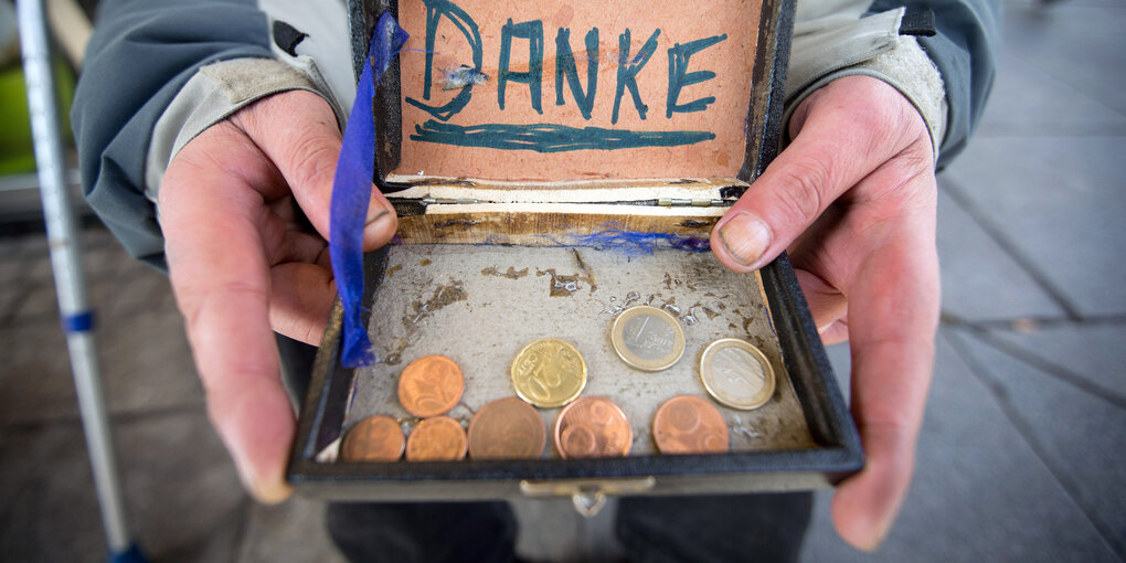 Zwei Hände halten eine Schatulle mit Kleingeld, darüber steht "Danke"