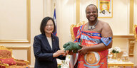 Eswatinis König Mswati in traditioneller Kleidung überreicht der taiwanischen Präsidenten ein Geschenk: ein kleines Tier aus Stein