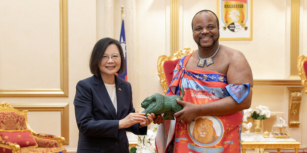 Eswatinis König Mswati in traditioneller Kleidung überreicht der taiwanischen Präsidenten ein Geschenk: ein kleines Tier aus Stein