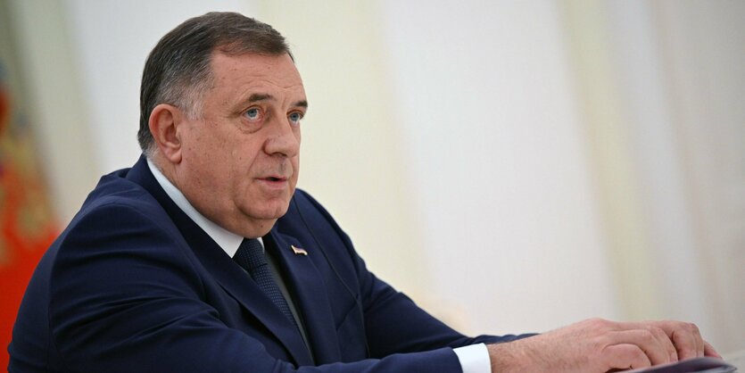 Milorad Dodik, ein weißer Mann mit grauem Haar, sitzt mit Anzug an einem Tisch