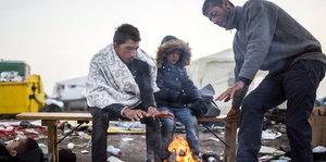 Flüchtlinge in einem Lager in Röszke sitzen an einem Lagerfeuer