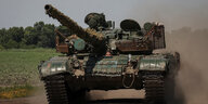 Ukrainische Militärangehörige fahren in einem Panzer durch die Landschaft