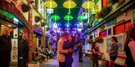 Ein Pärchen küsst sich in einer irischen Gasse unter Deko aus beleuchteten Regenschirmen
