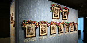 historische Fotos einer Familie, viele Kinder in einer Reihe, die Rahmen mit Blumenkränzen geschmückt