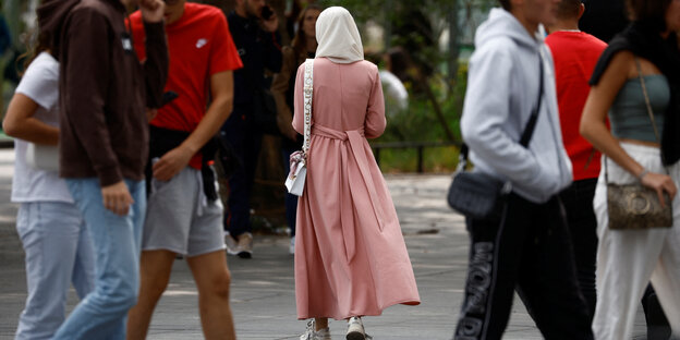 Jugendliche, dazwischen eine Frau in einer Abaya.