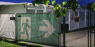 Fluchtweg-Symbol an einem Zaun.