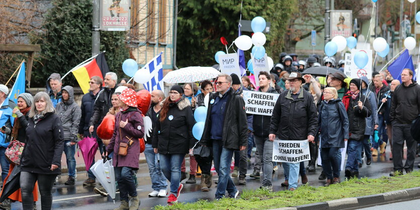 Eine Demo mit einigen Menschen und Plakaten