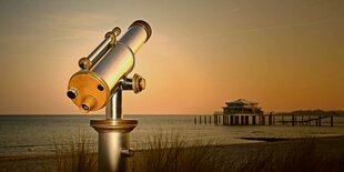 Ein Fernrohr am Timmendorfer Strand, am Horizont ein Teehaus