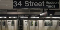 Eine U-Bahn und ein U-Bahn-Schild in Manhattan.