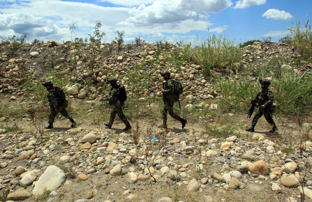 Vier Soldaten laufen Streife an der Grenze.