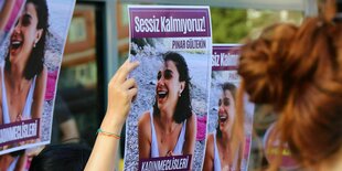 Menschen halten Protestplakate in die Höhe