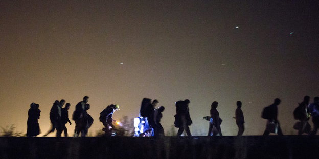 Eine Gruppe von Flüchtenden in der Nacht.