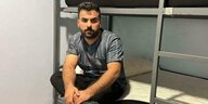 Mohamed Rahmatinia sitzt auf einem Metall-Doppelstockbett