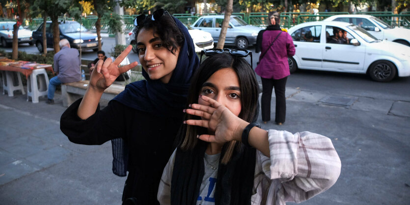 Zwei iranische Frauen posieren für ein Foto, ohne Kopftuch, das ihre Haare bedeckt.