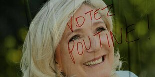 Wahllakat von Marine Le Pen auf dem mit rotem Filzstift steht: Votez Poutine (Wählt Putin)