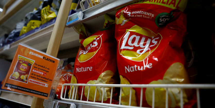 Ein Schild mit der Aufschrift „Schrumpfflation, das Gewicht dieses Produkts ist gesunken und der von unserem Lieferanten berechnete Preis ist gestiegen" in einem Supermarkt in der Nähe von Paris