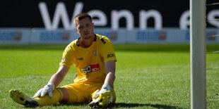 Osnabrücks Torwart Lennart Grill sitzt nach dem Tor zum 7:0 auf dem Feld