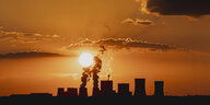 schwarzer Rauch vom Kohlekraftwerk Boxberg steigt vor Himmel im Sonnenuntergang empor