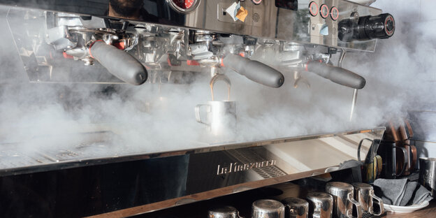 Eine Kaffeemaschine mit Tassen dampft: Rösterei und Café in einem: die „Blaue Bohne“ in Friedrichshain