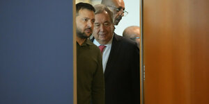 Wolodymyr Selenskyj und Antonio Guterres gucken durch einen Türspalt