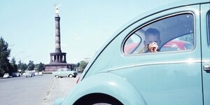 Blauer VW in Berlin vor der Siegessäule. Im Auto ist ein kleiner Junge.