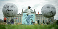 Zwei große Ballons, die mit dem Konterfei von Olaf Scholz und Christian Lindner bedruckt sind, vor dem Berliner Reichstagsgebäude