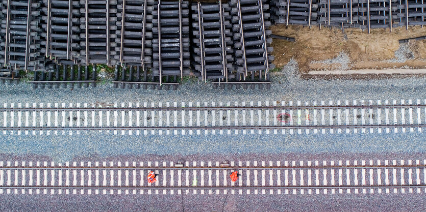 Zwei Bahngleise, daneben ein Lager mit Bahnschwellen