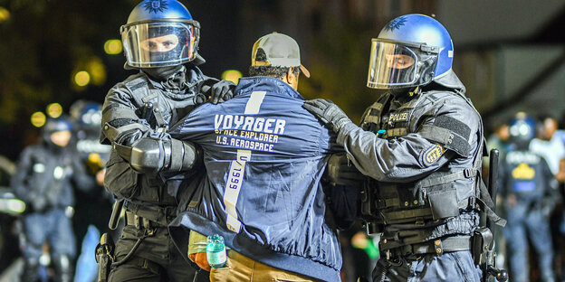 Zwei Polizisten nehmen einen Mann fest bei den Ausschreitungen bei einer Eritrea-Veranstaltung in Stuttgart