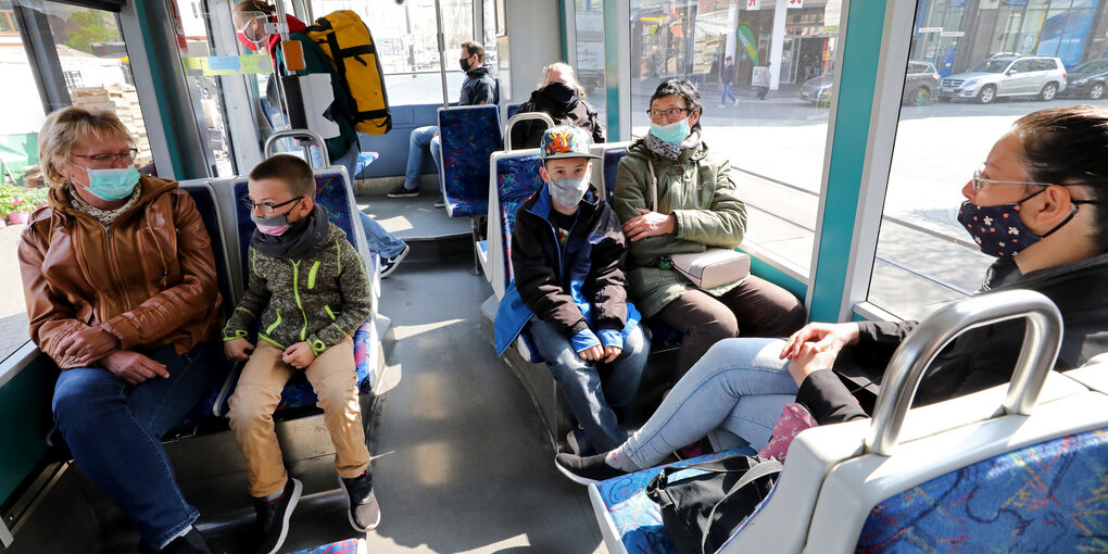 Mütter mit Kindern sitzen in einer Straßenbahn.