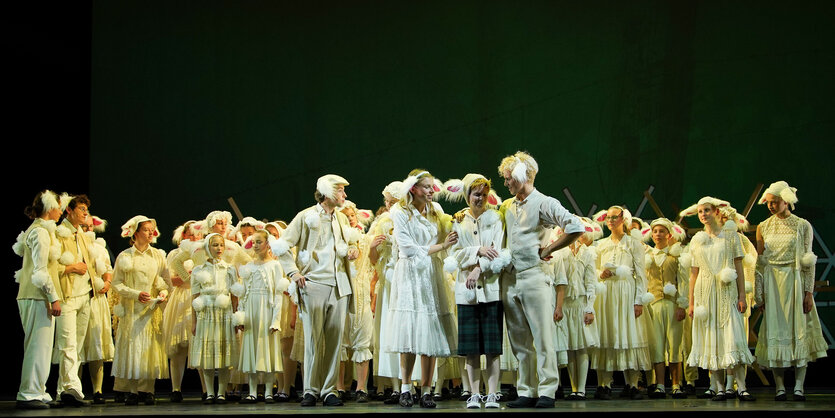 Menschen in Schafskostümen auf der Theaterbühne