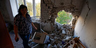 Eine Frau steht in ihrer Wohnung in Donezk nach einem russsichen Raktenangriff