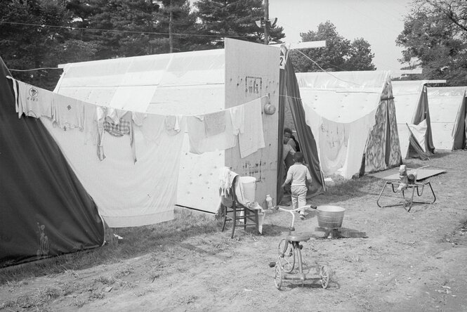 Schwarzweiß Foto eines Protestcamp Ende der 60er Jahre in Washington D.C. Darauf zu sehen zwei Schwarze Kinder, Spielzeug und aufgehängte Wäsche