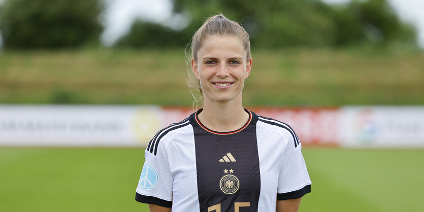 Tabea Sellner steht im Nationaltrikot auf einem Fußballplatz.