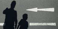 Der Schatten von einem Mann und einem Kind sind auf einer Straße