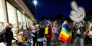 Jubelnde Menschen mit LBTG Flagge um die SChultern und einem großen FCK -AFD Stinkefinger