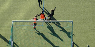 Kinder spielen auf einem Kunstrasenplatz Fußball