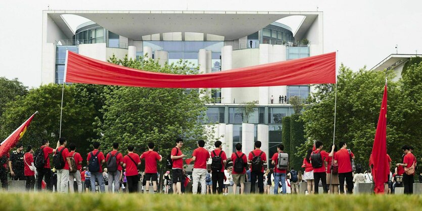 Chinesische Studenten begrüßen die chinesische Delegation bei den deutsch-chinesischen Regierungskonsultationen vor dem Bundeskanzleramt mit Fahnen und Transparenten.