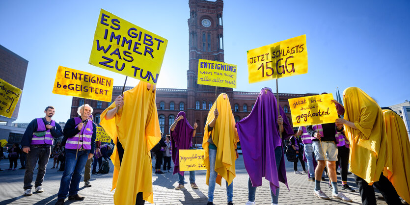 Performance von "Enteignungsgespenstern" in gelben und lilafarbenen Umhängen vor dem Roten Rathaus